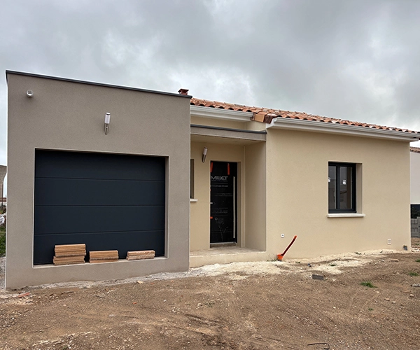 Construction maison neuve avec garage anthracite et enduit beige à Béziers
